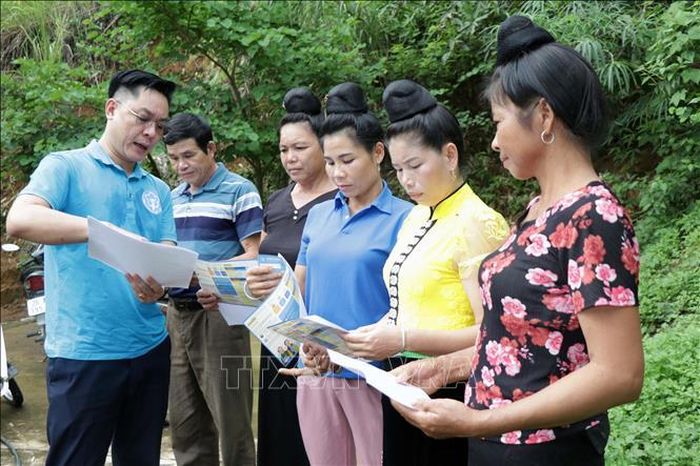 Cán bộ Bảo hiểm xã hội huyện Mường La tuyên truyền về chính sách bảo hiểm y tế cho người dân.