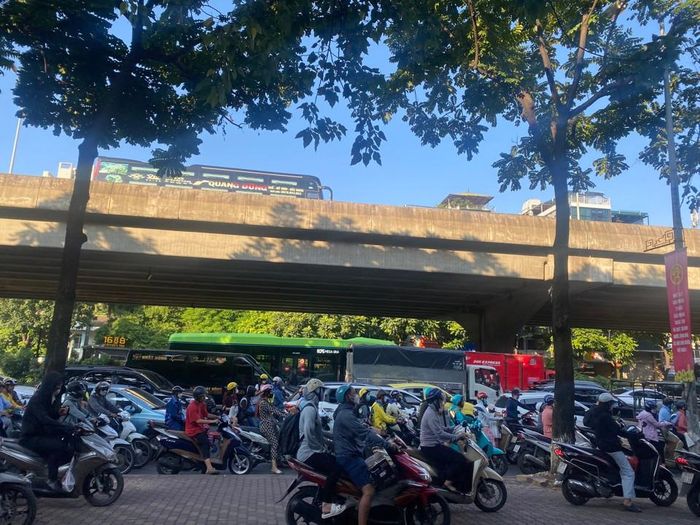 Xe máy trèo lên vỉa hè để di chuyển trên đường Nguyễn Xiển.