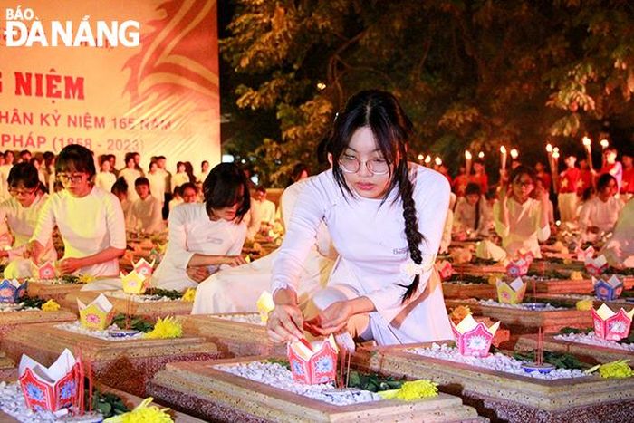 Những ngọn nến tri ân được các em học sinh thắp sáng trên những mộ phần. Ảnh: X.D