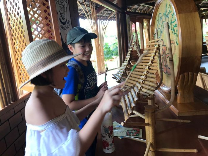 Du khách nhí thích thú trải nghiệm nhạc cụ truyền thống tại Làng nghề Trường Sơn
