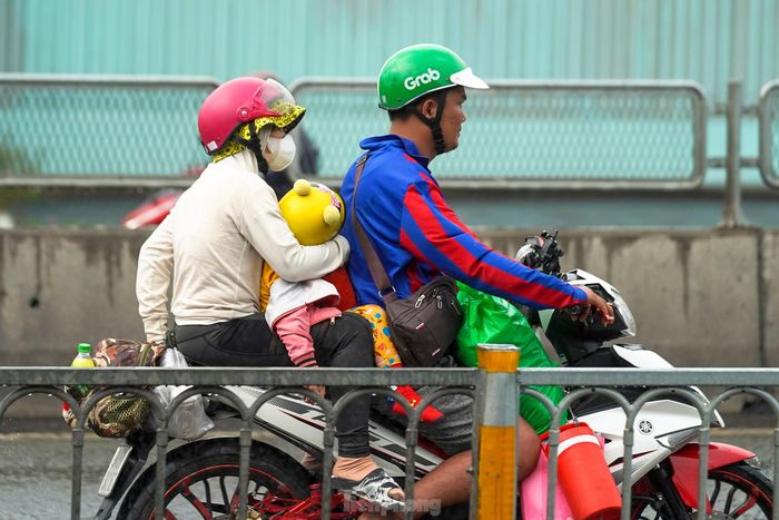 Những cơn mưa bất chợt khiến chặng đường trở lại TPHCM sau đợt nghỉ lễ của người dân thêm vất vả. "Hôm nay, trời nắng không gắt nhưng không khí khá khó chịu, đoạn mưa, đoạn nắng nên mệt rã rời" - anh Lê Văn Quốc Cang (ngụ tỉnh Trà Vinh) chia sẻ khi dừng chờ đèn đỏ đoạn gần cảng Bon Bon.