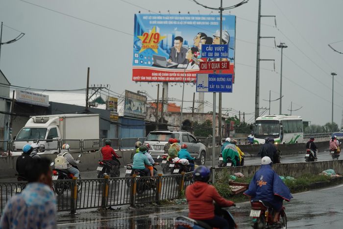 Một cơn mưa lớn bất chợt xuất hiện ở khu vực cầu vượt Bình Thuận, đầu đường Nguyễn Văn Linh (huyện Bình Chánh, TPHCM) khiến nhiều người không kịp trở tay.