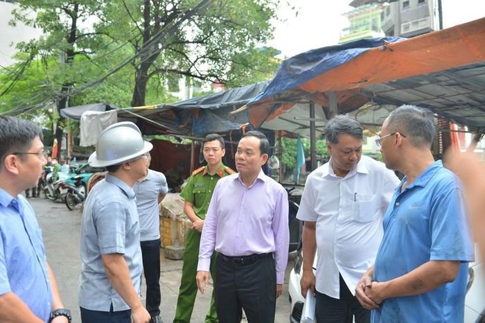 Phó Thủ tướng Chính phủ Trần Lưu Quang nghe báo cáo về vụ hỏa hoạn. (Ảnh: TTXVN phát)