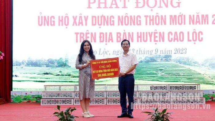 Đại diện doanh nghiệp trao biểu trưng kinh phí hỗ trợ xây dựng NTM cho lãnh đạo UBND huyện Cao Lộc