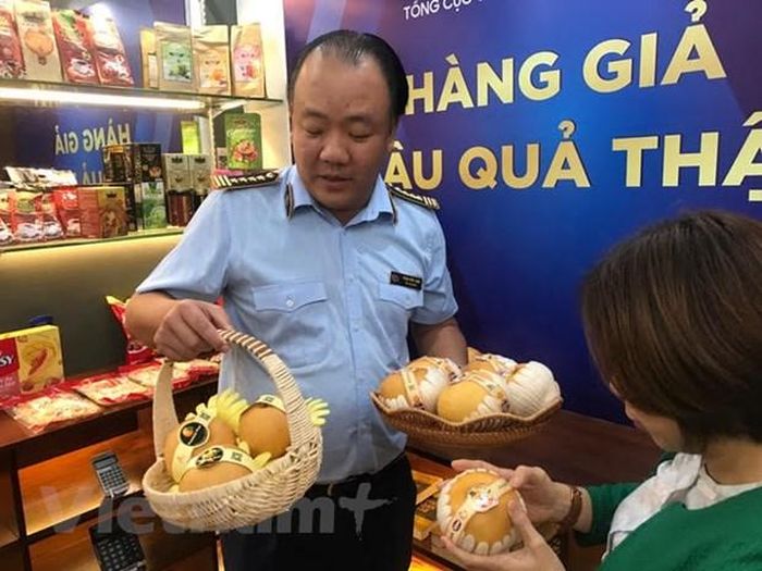 Ông Trần Hữu Linh hướng dẫn cách phân biệt hàng thật, hàng giả. (Ảnh: Đức Duy/Vieetnam+)