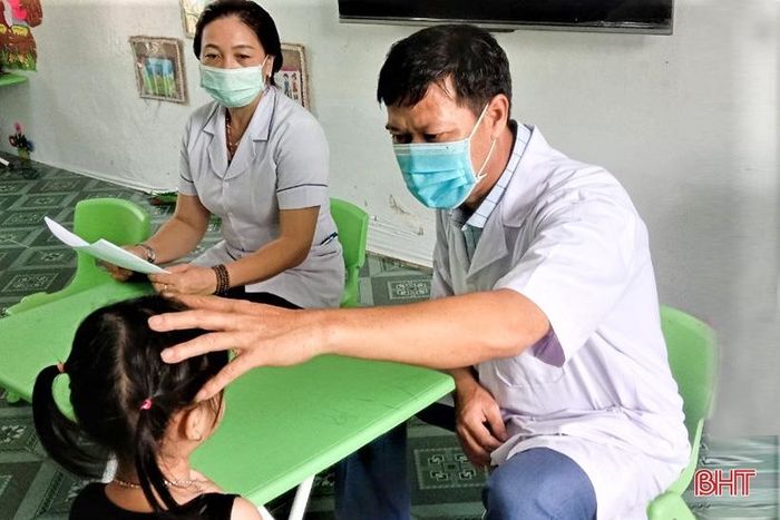 Cán bộ y tế kiểm tra, hướng dẫn điều trị bệnh đau mắt đỏ cho học sinh.