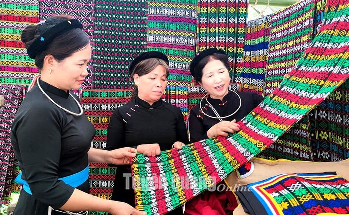 Các thành viên của Tổ hợp tác Thêu, dệt thổ cẩm xã Thượng Lâm trao đổi kinh nghiệm thêu hoa văn trên tấm chăn thổ cẩm.