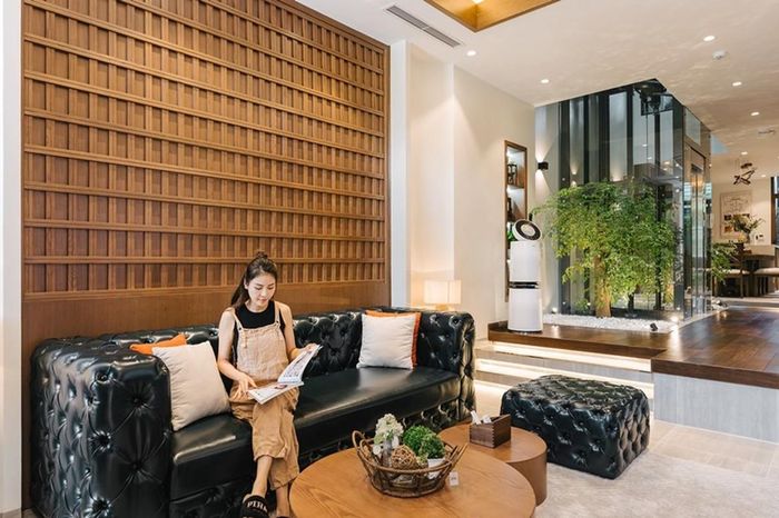 Phòng khách đặt bộ sofa màu đen sang trọng kết hợp với bàn gỗ.