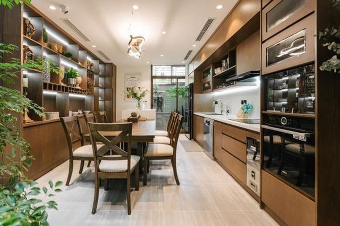 Khu vực ăn uống, nấu nướng được nâng cao, kết nối với phòng khách bằng bậc thang ngắn.