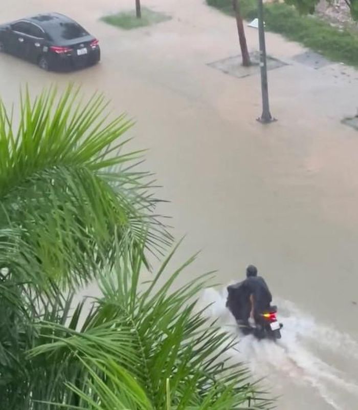 Xe máy và xe ô tô đi tìm chỗ đỗ cao hơn khi tuyến đường nước ngập và nước ngày càng dâng cao. (Ảnh: Trần Thiện)