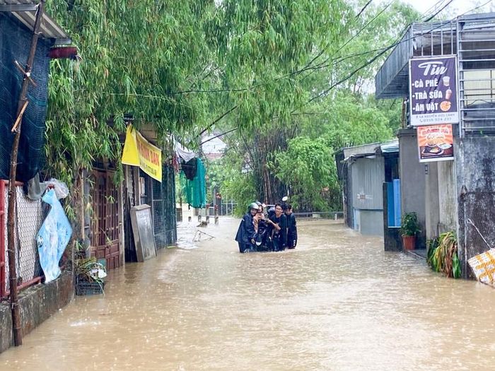 Sinh viên di chuyển xe máy ra khỏi khu vực ngập lụt.