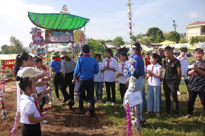 Thiếu niên, nhi đồng chào đón Ban giám khảo chấm điểm hội trại.
