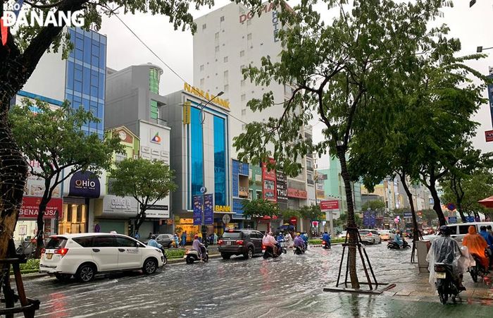Đường Nguyễn Văn Linh đoạn bị ngập, nhiều phương tiện xe gắn máy chạy trên vỉa hè.