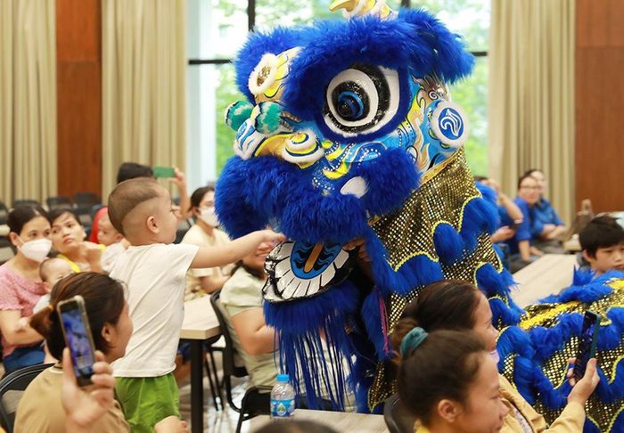 Em nhỏ thích thú khi vui đùa với lân...