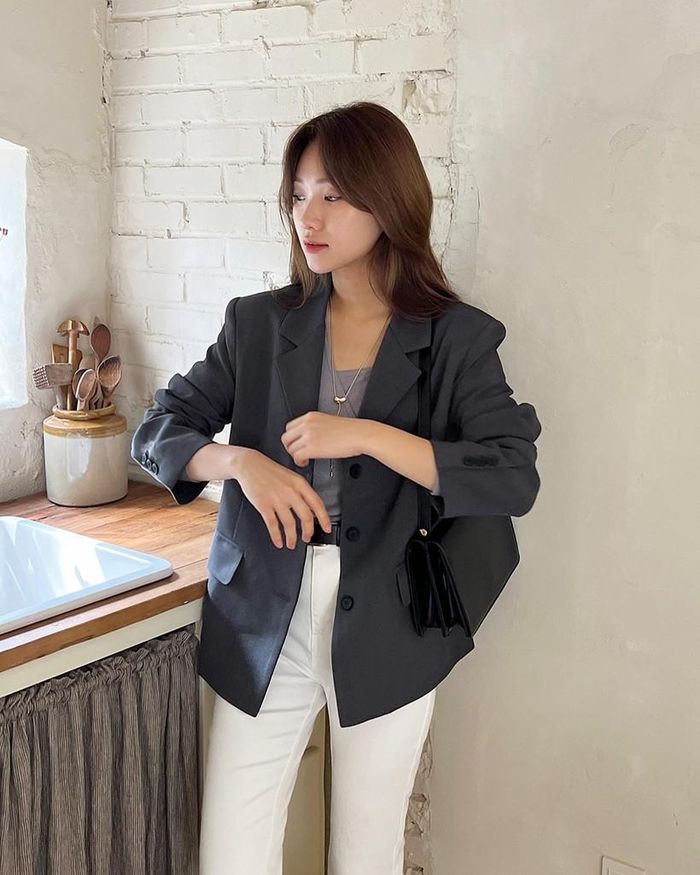 Công thức gồm áo thun, blazer màu xám đậm và quần trắng gây ấn tượng ở nét trang nhã, tinh tế. 
