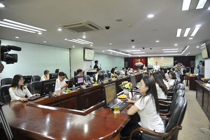 Cán bộ thuế hỗ trợ người nộp thuế tại điểm cầu Văn phòng Cục Thuế TP. Hà Nội. Ảnh: HG