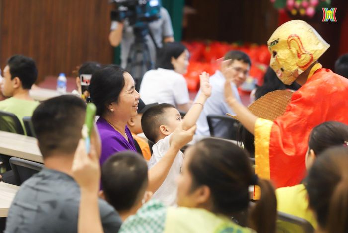Một em nhỏ thích thú giao lưu với chú Cuội trong tiếng nhạc rộn ràng mang Tết Trung thu về sớm.