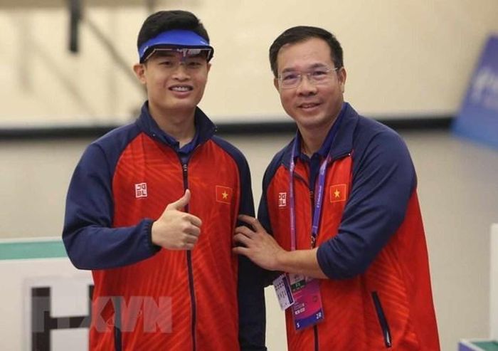 Xạ thủ Phạm Quang Huy (trái) và Huấn luyện viên Hoàng Xuân Vinh ăn mừng chiến thắng. (Ảnh: TTXVN phát)