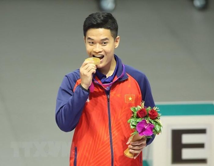 Xạ thủ Phạm Quang Huy ăn mừng trên bục nhận huy chương Vàng tại ASIAD 19. (Ảnh: TTXVN phát)