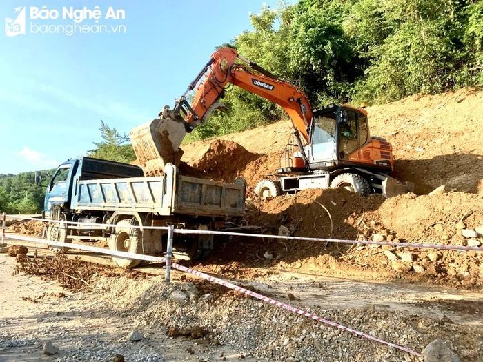  Tích cực bạt mái ta luy dương quả đồi bên cạnh vết sạt lở để mở đường tạm giúp các phương tiện lưu thông. Ảnh: Quang An 
