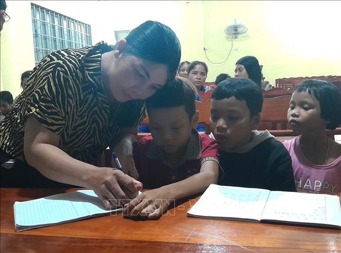 Cô Tạ Thị Hoan hướng dẫn học viên viết chữ.
