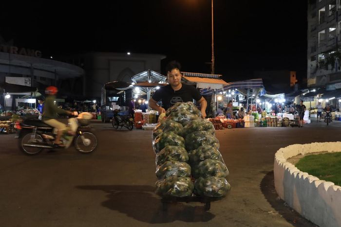Một thanh niên vận chuyển hàng bằng phương tiện thô sơ.
