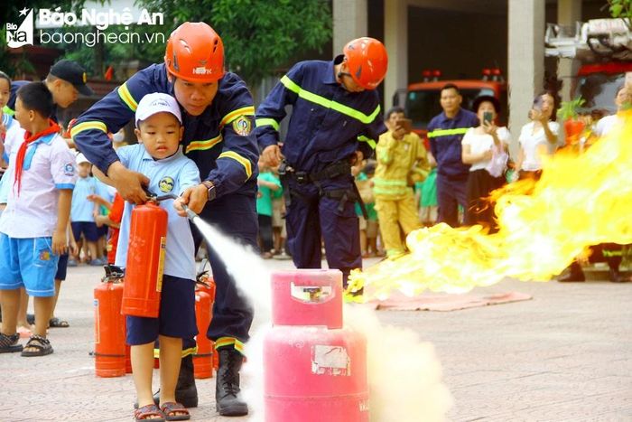  Học sinh được thực hành sử dụng bình chữa cháy xách tay dập tắt đám cháy do rò rỉ khí gas. Ảnh: Quang An 