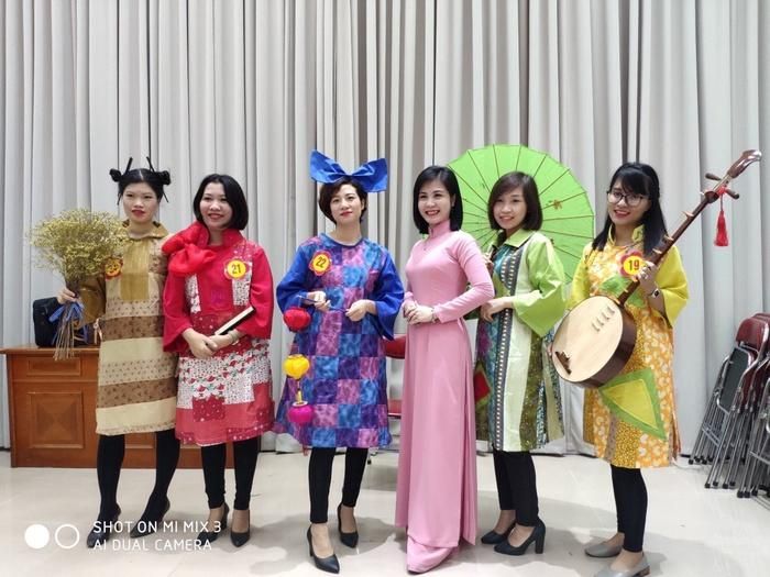 Trung tá Kim Dung (áo dài hồng) cùng tác phẩm của mình trong "Hội thi thời trang thiết kế từ vải vụn" trong một hoạt động của Hội phụ nữ diễn ra tại đơn vị