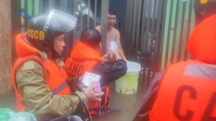 Cùng ngày, Cảnh sát cơ động - Công an TP Đà Nẵng tiếp tế bánh mì, mì tôm, nước uống cho người dân các khu vực bị ngập thuộc phường Hòa Minh, quận Liên Chiểu. Ảnh: T.S