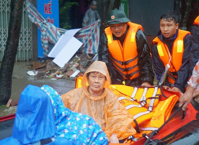 Các lực lượng nỗ lực đưa người dân ra khỏi vùng ngập sâu.