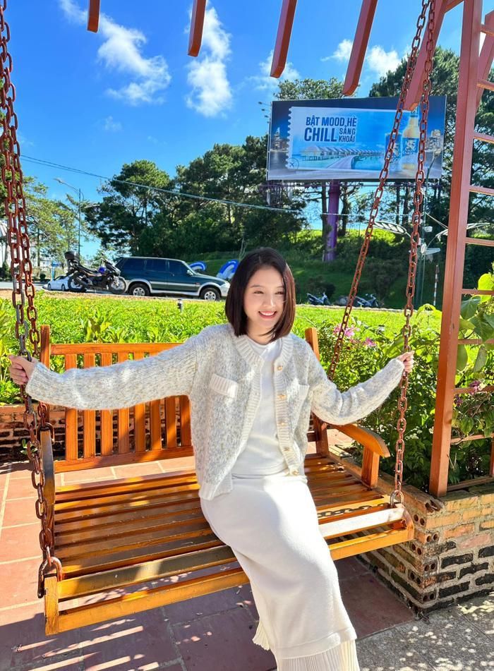 Vi vu hồ Xuân Hương, sao nữ chọn cho mình mẫu váy len phủ tông trắng trang nhã phối cùng áo khoác dệt kim với điểm nhấn là hàng cúc ánh kim.