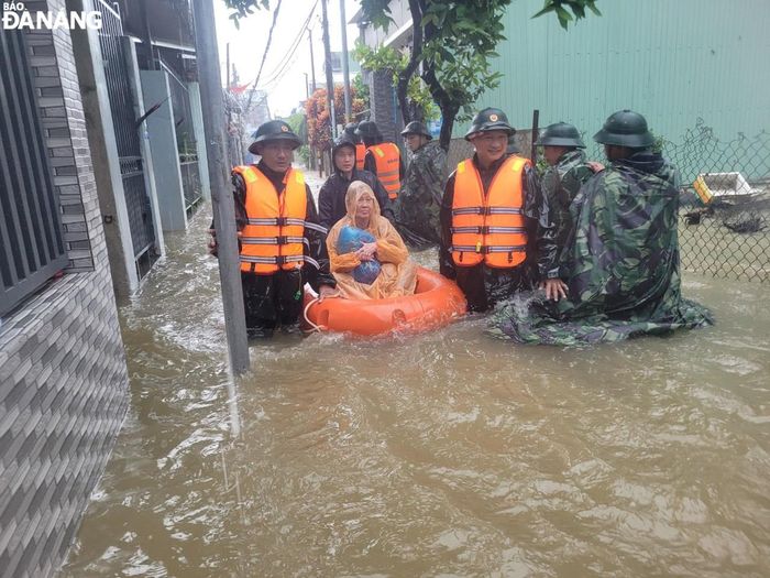 Cán bộ, chiến sĩ Trung đoàn 971, Bộ Chỉ huy Quân sự thành phố hỗ trợ người dân quận Liên Chiểu bị ngập úng đến nơi cao ráo, án toàn.