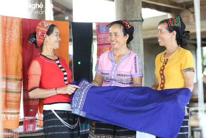 Tranh thủ lúc rảnh rang, các bà, mẹ đem tấm thổ cẩm ra chia sẻ với nhau. Ảnh: Đình Tuyên