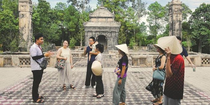  Thành viên của JiH (trái) giới thiệu đến du khách về văn hóa, di sản Huế