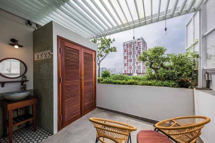Khu vực vệ sinh được đặt bên ngoài căn hộ, kết hợp với bàn ghế, biến ban công thành nơi thư giãn.