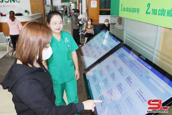 Nhân viên y tế Bệnh viện đa khoa Cuộc Sống hướng dẫn nhân dân lấy số tự động khám chữa bệnh.