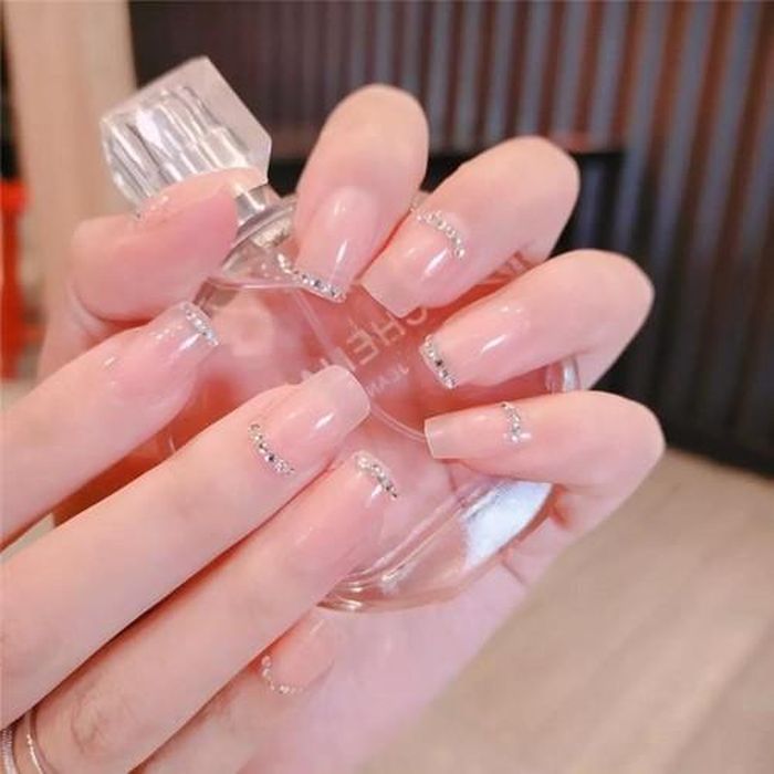 Ngoài sắc nude chủ đạo, những chi tiết trang trí trên móng lấp lánh như ánh sao cũng giúp bàn tay thêm nổi bật và sang trọng.