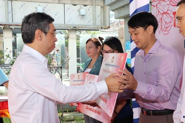 Phó Bí thư Thành ủy TPHCM Nguyễn Phước Lộc trao bảng tượng trưng hỗ trợ chăm lo người nghèo cho quận, huyện. (Ảnh: Ủy ban Mặt trận Tổ quốc TPHCM)