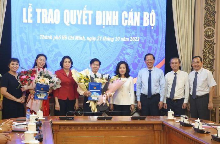 Chủ tịch UBND TP Phan Văn Mãi cùng các đại biểu trao quyết định và tặng hoa chúc mừng ông Đào Minh Chánh và bà Hồ Thị Quyên