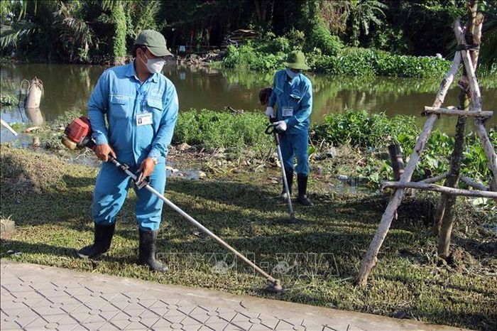 Công nhân vệ sinh tiến hành hoạt động phát quang, dọn cỏ hưởng ứng lễ phát động.