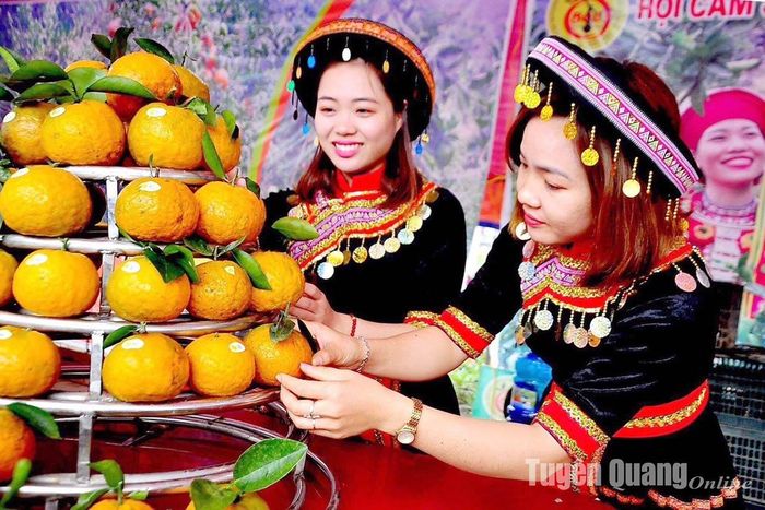 Đảng viên Nguyễn Thị Cúc (từ phải qua) giới thiệu cam của HTX nông nghiệp xanh Yên Lâm tại hội chợ cam sành hàm Yên năm 2022.