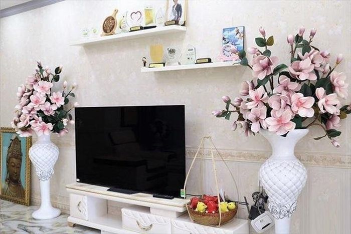 Kệ ti vi với hai chậu hoa giả lớn do vợ nam diễn viên kết và bày trí giữa phòng khách. Ảnh: chụp màn hình