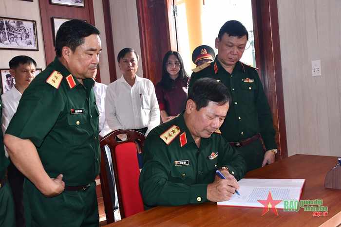 Thượng tướng Lê Huy Vịnh ghi sổ lưu niệm.