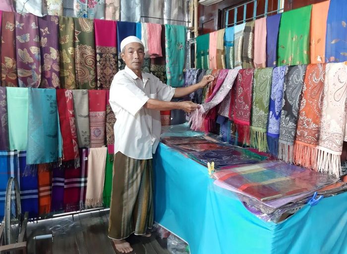 Ông Mohamad ở ấp Phũm Soài (xã Châu Phong, thị xã Tân Châu) giới thiệu sản phẩm dệt thổ cẩm Châu Giang với du khách. (Ảnh: Phương Nghi)
