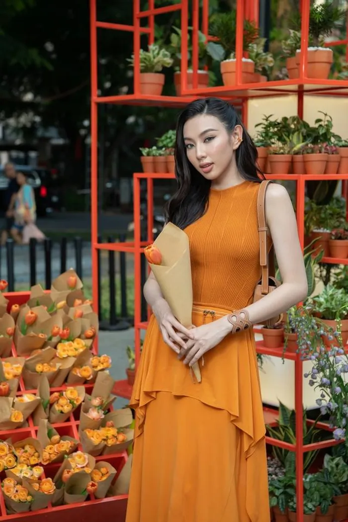 Hoa hậu Thùy Tiên nổi bần bật giữa phố trong trang phục mang sắc cam rực rỡ với kiểu dáng thướt tha, nhẹ nhàng, tôn lên vóc dáng vạn người mê. Mỹ nhân đình đám ghi điểm với visual sắc sảo và kiểu tóc, phụ kiện ton sur ton với outfit