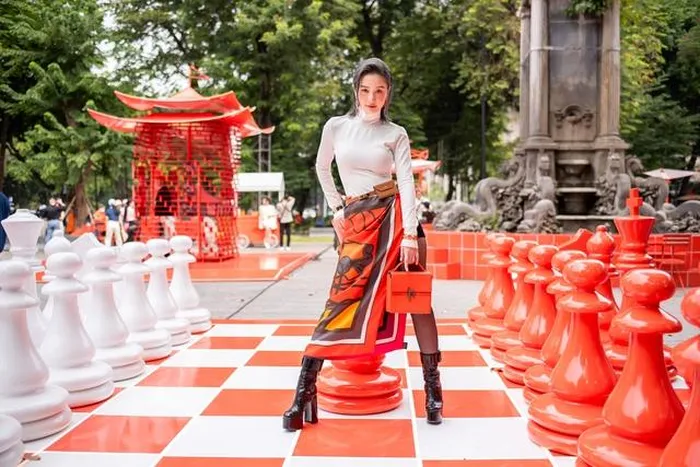  Jun Vũ mix áo ôm sát cổ lọ trắng phối cùng chân váy họa tiết, boots đen. Người đẹp cũng lựa chọn kiểu tóc, phụ kiện đi kèm vô cùng cá tính, tô điểm cho diện mạo thêm ấn tượng 