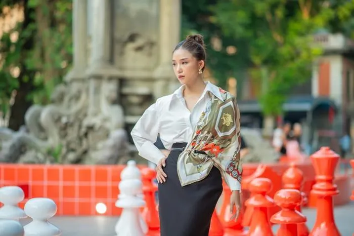  Salim lại có phần đơn giản, trang nhã hơn trong combo sơ mi trắng - chân váy đen dài, tập trung ánh nhìn vào phần khăn họa tiết màu sắc trứ danh của Hermès 