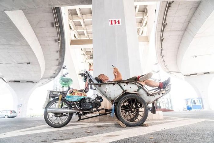 Ông Khỏe đọc thông tin thời sự trên điện thoại dưới gầm cầu Hoàng Văn Thụ tháng 10/2023