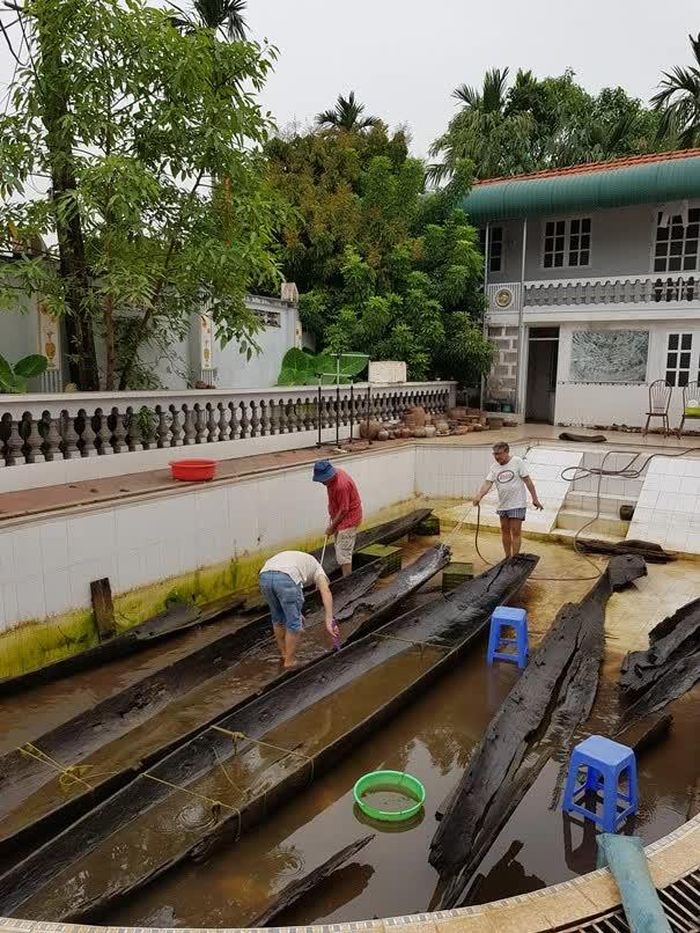 Các chuyên gia Việt Nam và Úc đang làm việc trong bể ngâm các con thuyền độc mộc vớt từ sông Kinh Thày 2017-2018 (giáo sư Peter Bellwood mặc áo đỏ, đội mũ)