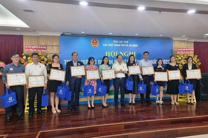 Ông Nguyễn Tiến Dũng - Phó Cục trưởng Cục Thuế TP. Hồ Chí Minh, trao phần thưởng cho một số doanh nghiệp nộp thuế tiêu biểu tại hội nghị. Ảnh Đỗ Doãn
